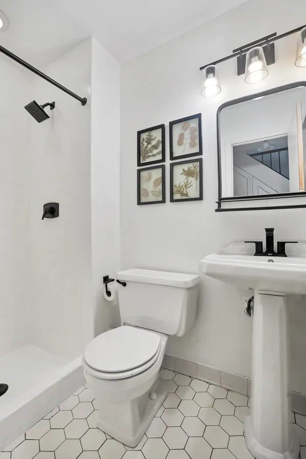 a bathroom with a toilet a sink a mirror and a bathtub