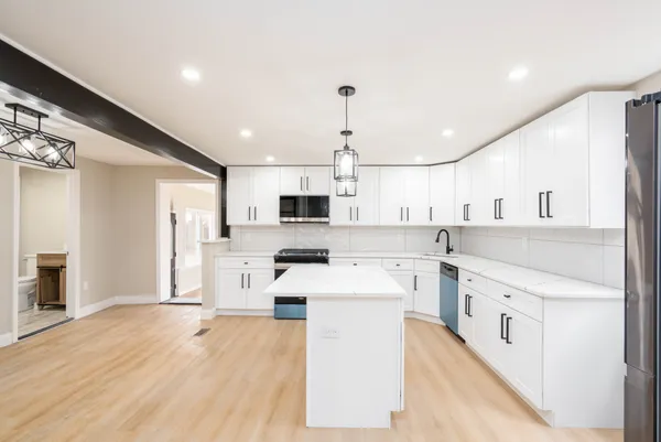 a large white kitchen with cabinets and stainless steel appliances