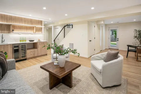 a living room with furniture potted plant and kitchen view