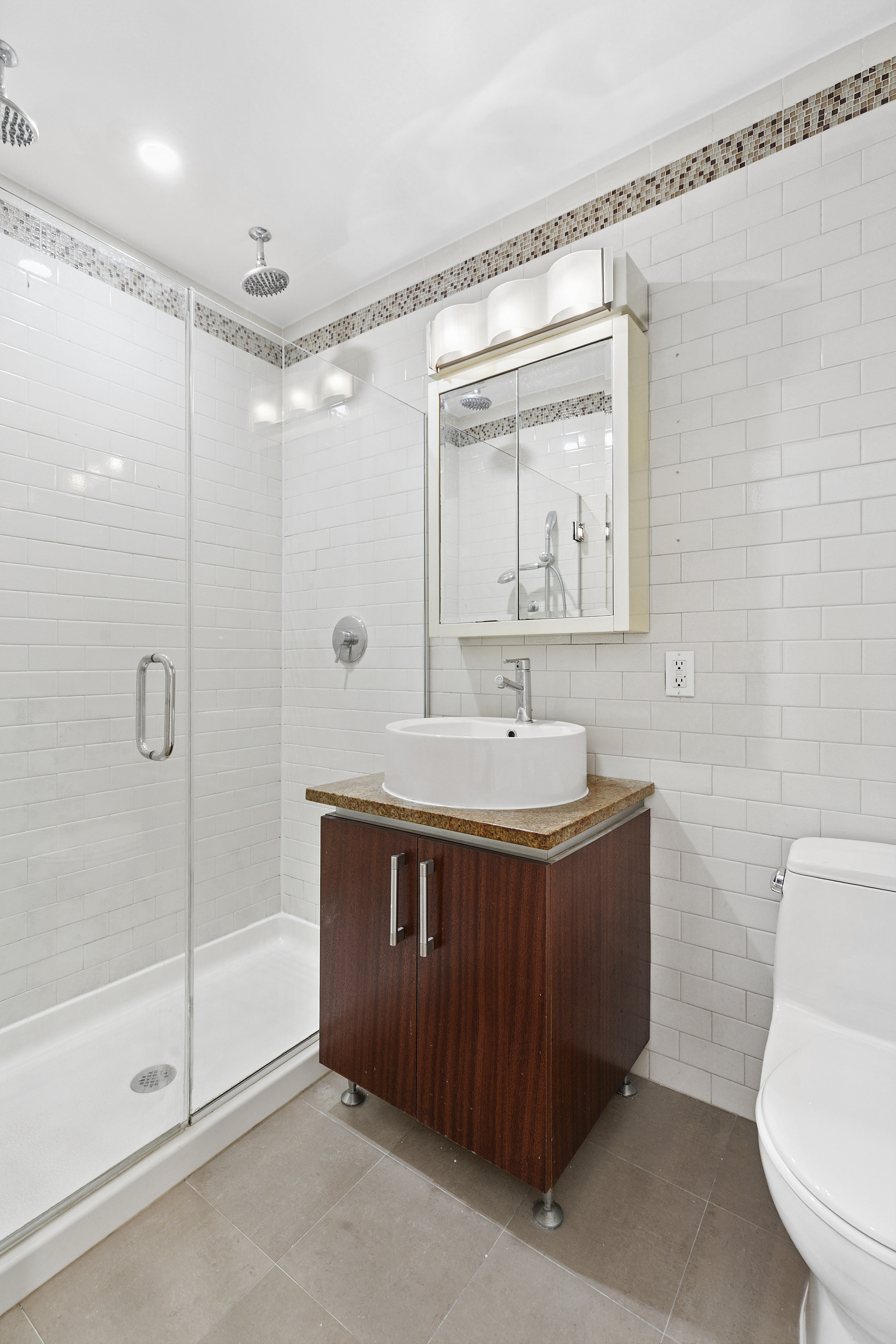 41-26 27th Street, Unit 4H Queens, NY 11101 - Photo 11 of 21 a bathroom with a sink a toilet and shower