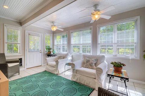 a living room with patio furniture and a large window