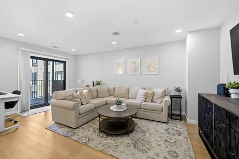 a living room with furniture a rug and white walls