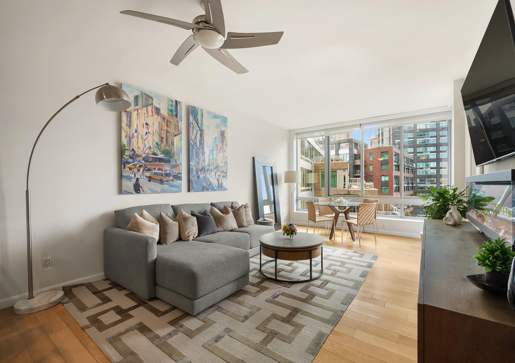 46-30 Center Boulevard, Unit 707 Queens, NY 11109 - Photo 2 of 23 a living room with furniture a flat screen tv and a floor to ceiling window
