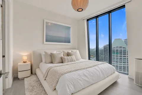 a bedroom with a large bed and a large window