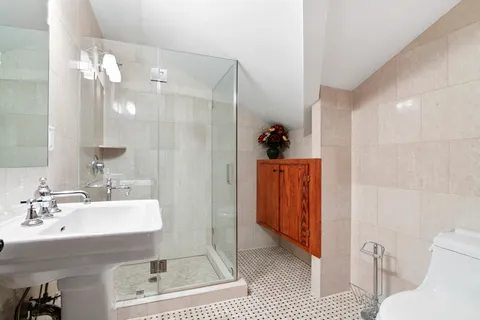 a bathroom with a sink a toilet and shower