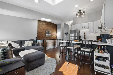 a living room with furniture kitchen view and a chandelier