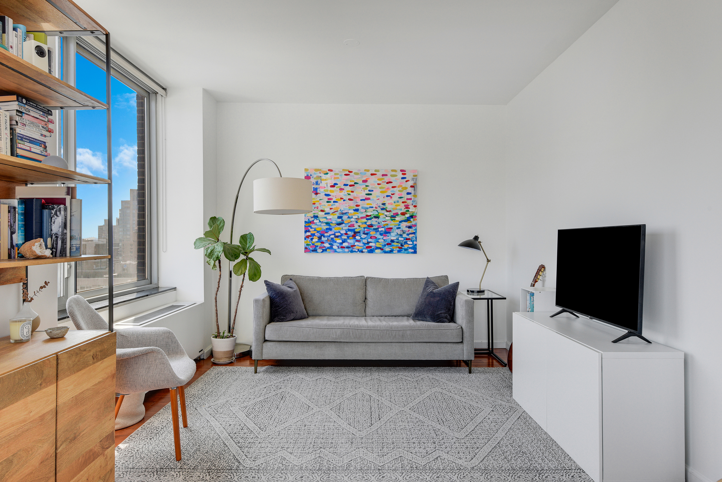 360 East 88th Street, Unit 22C Manhattan, NY 10128 - Photo 5 of 33 a living room with furniture and a flat screen tv