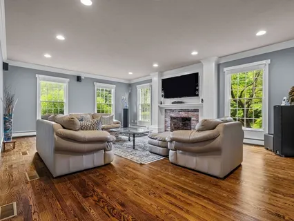 a living room with furniture a flat screen tv and a fireplace