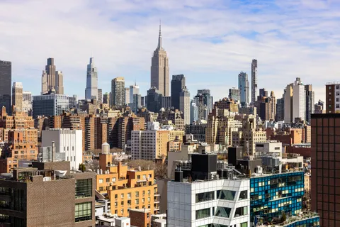 a bedroom with a bed a lamp and a large window with balcony view