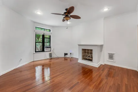 a view of empty room with wooden floor and fireplace