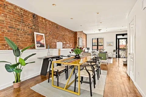 a view of a dining room with furniture and a potted plant