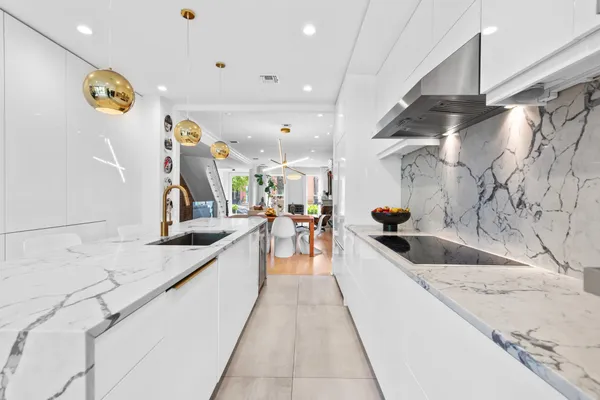 a large white kitchen with a lot of counter space and a sink