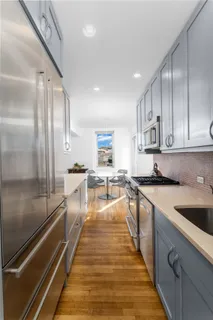 a large kitchen with stainless steel appliances lots of counter space and wooden floor