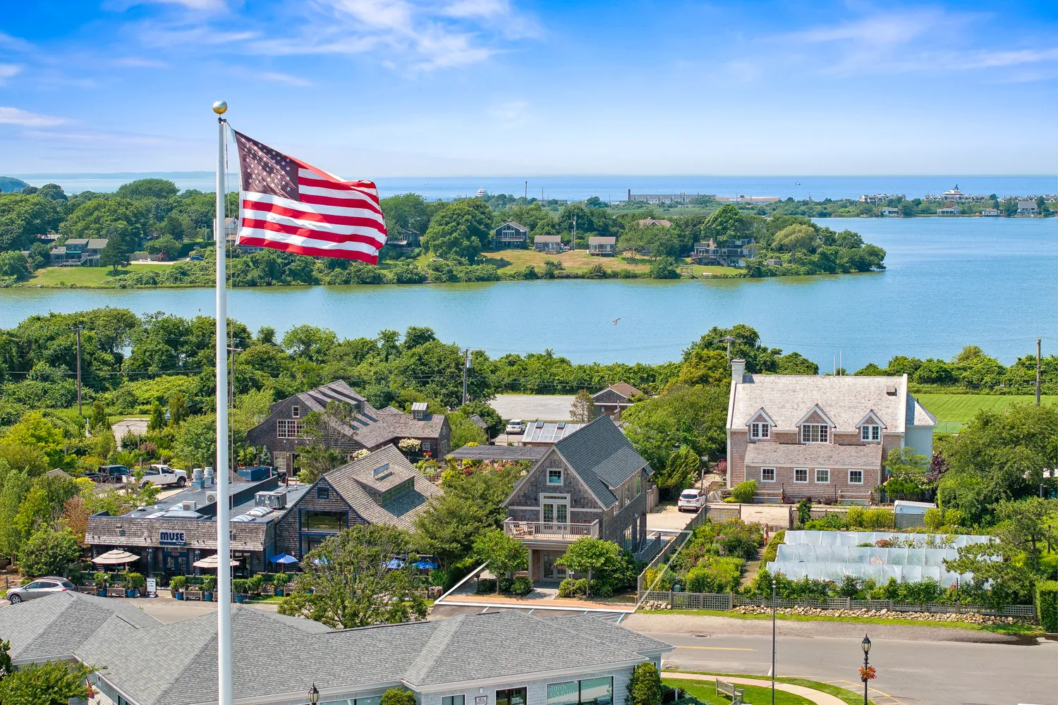 an aerial view of residential houses with outdoor space and lake view
