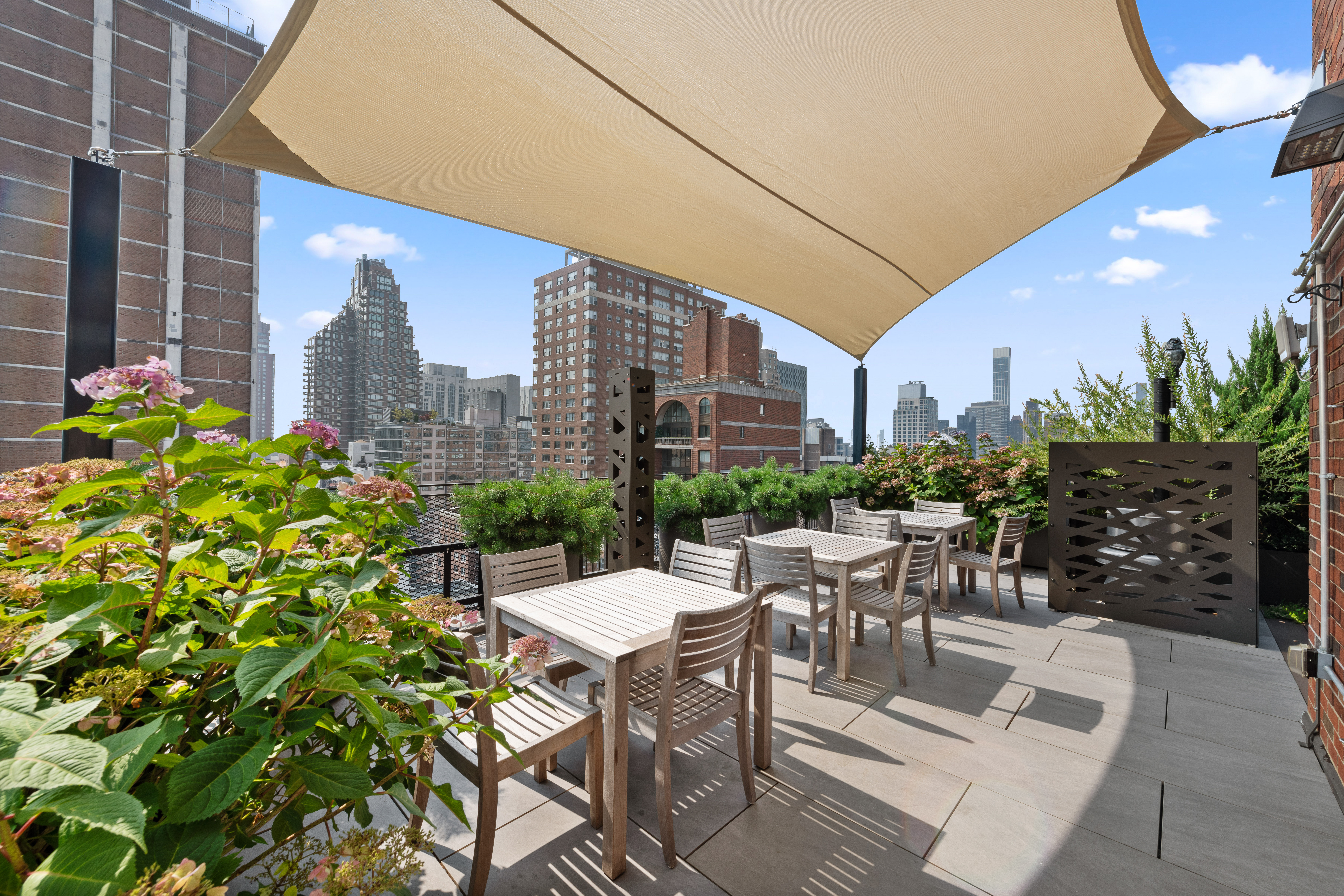 315 East 72nd Street, Unit 15M Manhattan, NY 10021 - Photo 17 of 18 a view of a patio with a table and chairs and potted plants