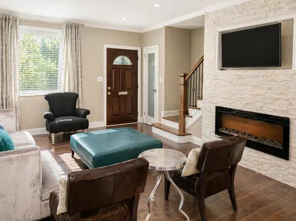 a living room with furniture a flat screen tv and a fireplace