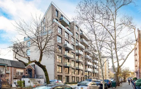 a front view of a building with large trees