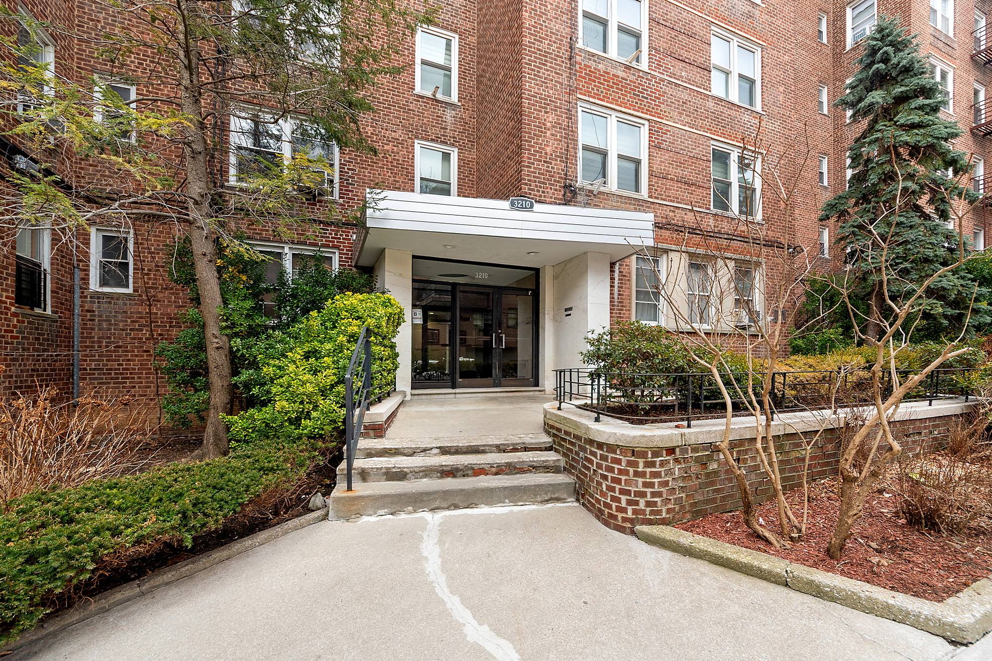 3210 Arlington Avenue, Unit 3D Bronx, NY 10463 - Photo 13 of 24 a view of a brick house with plants and large tree