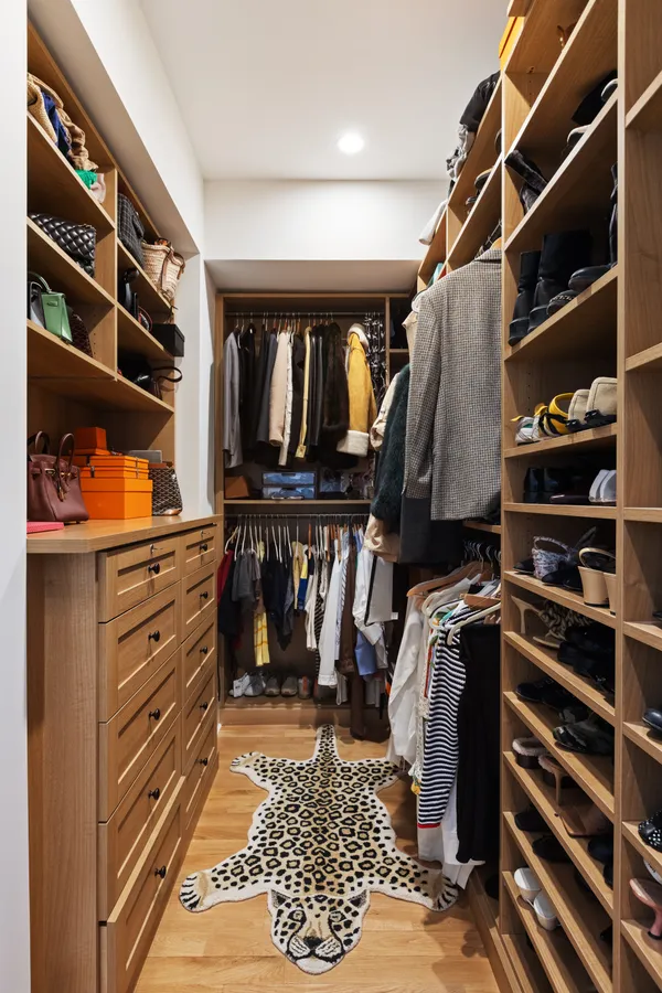 a view of walk in closet with clothes and shoes