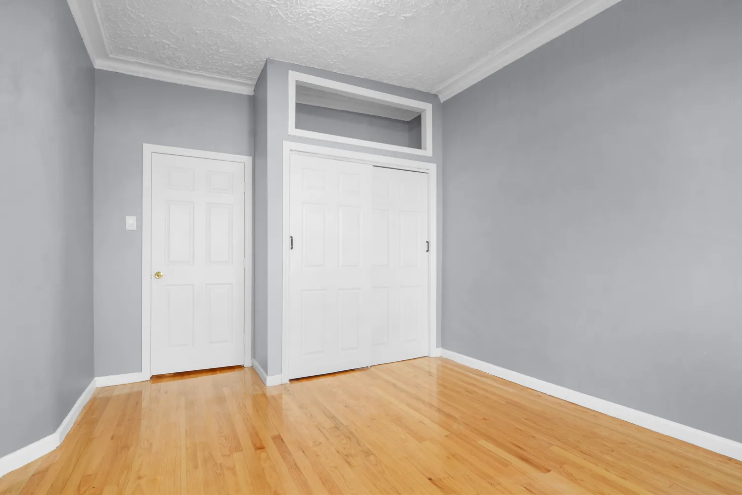a bedroom with a bed and a lamp on dresser
