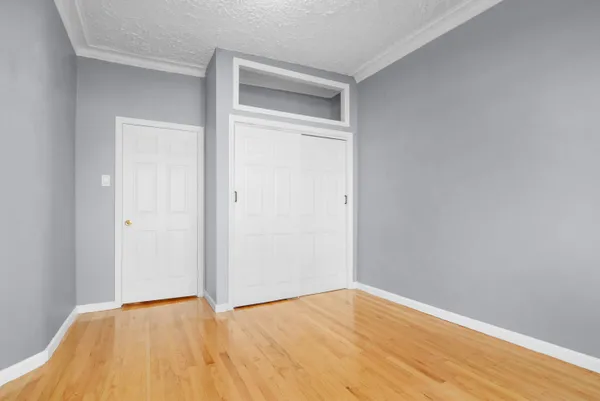a bedroom with a bed and a lamp on dresser