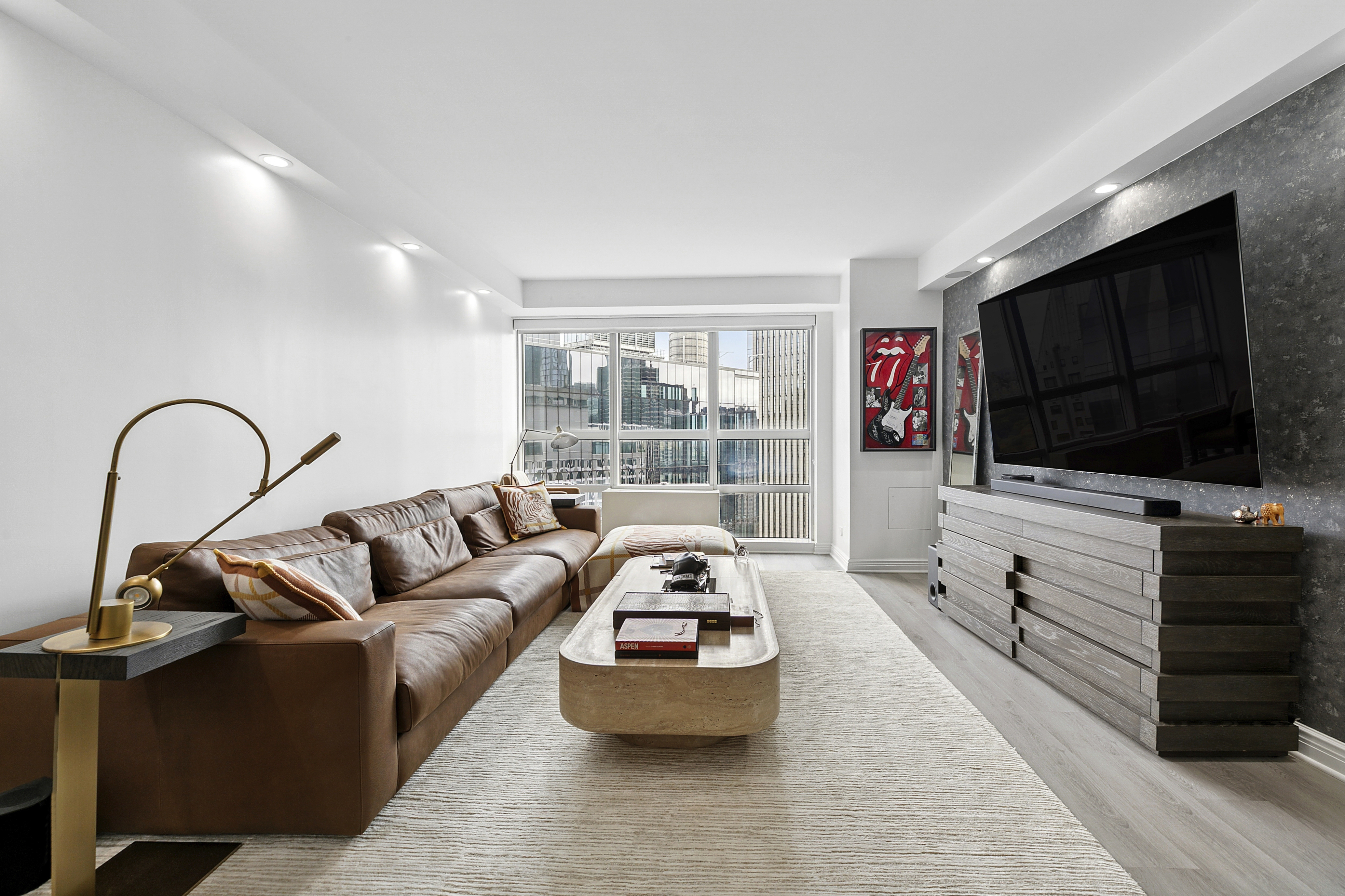 146 West 57th Street, Unit 47B Manhattan, NY 10019 - Photo 2 of 15 a living room with furniture and a flat screen tv