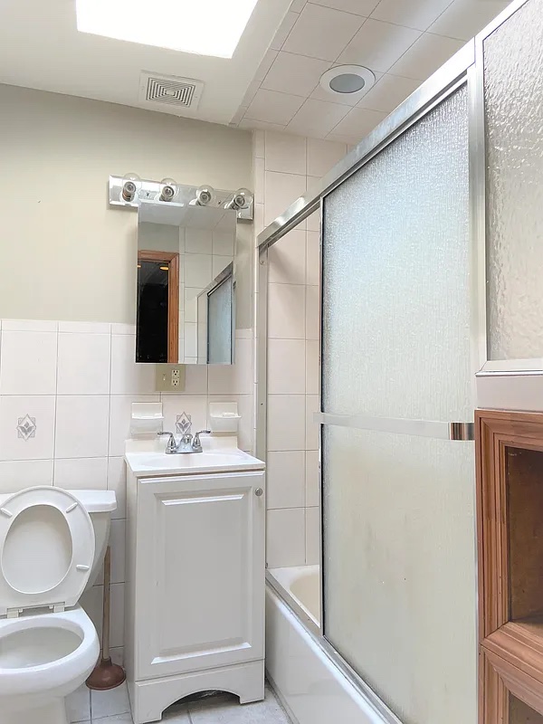 313 Van Buren Street Brooklyn, NY 11221 - Photo 18 of 20 a bathroom with a toilet sink and mirror