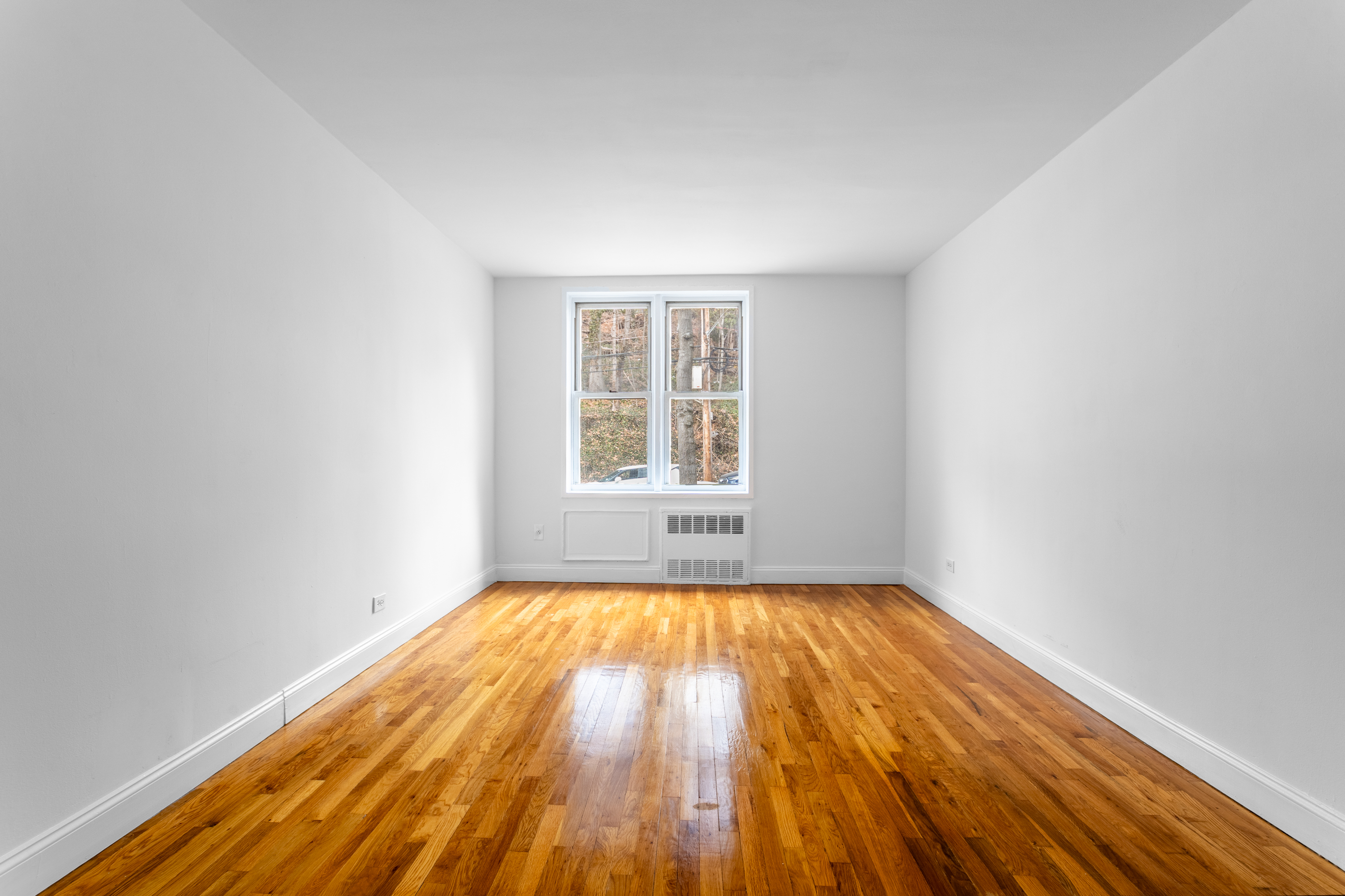 2750 Johnson Avenue, Unit 6E Bronx, NY 10463 - Photo 11 of 14 a view of an empty room with wooden floor and a window