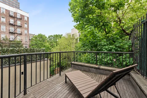 a view of balcony with wooden floor and fence