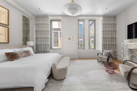 a bedroom with a bed and large windows