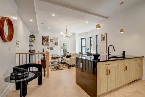 a living room with furniture a mirror and a sink