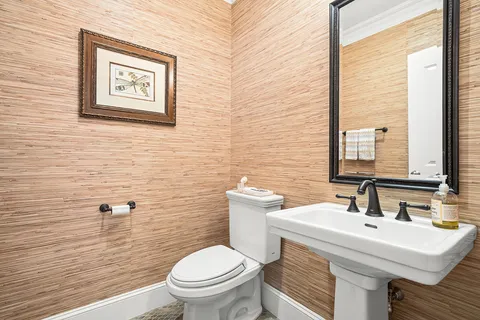 a bathroom with a toilet a sink and a mirror
