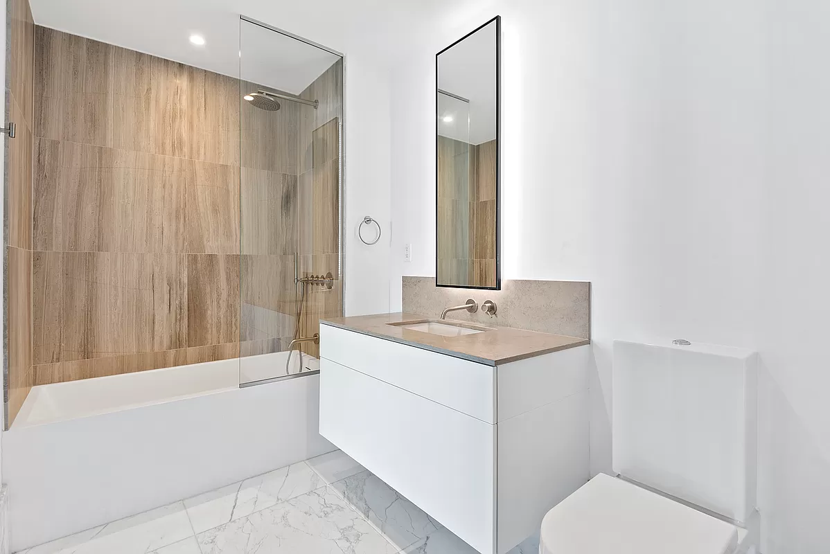 429 Kent Avenue, Unit 912 Brooklyn, NY 11249 - Photo 3 of 11 a bathroom with a granite countertop sink toilet and shower