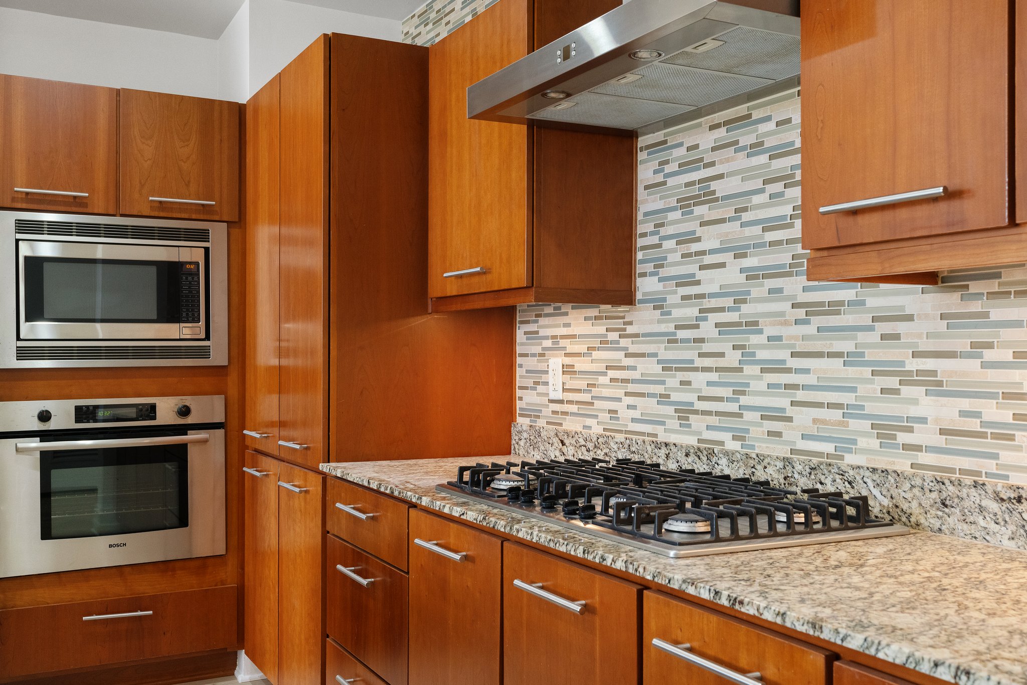 210 Lee Barton Drive, Unit 517 Austin, TX 78704 - Photo 2 of 32 a kitchen with granite countertop stainless steel appliances and brick cabinets