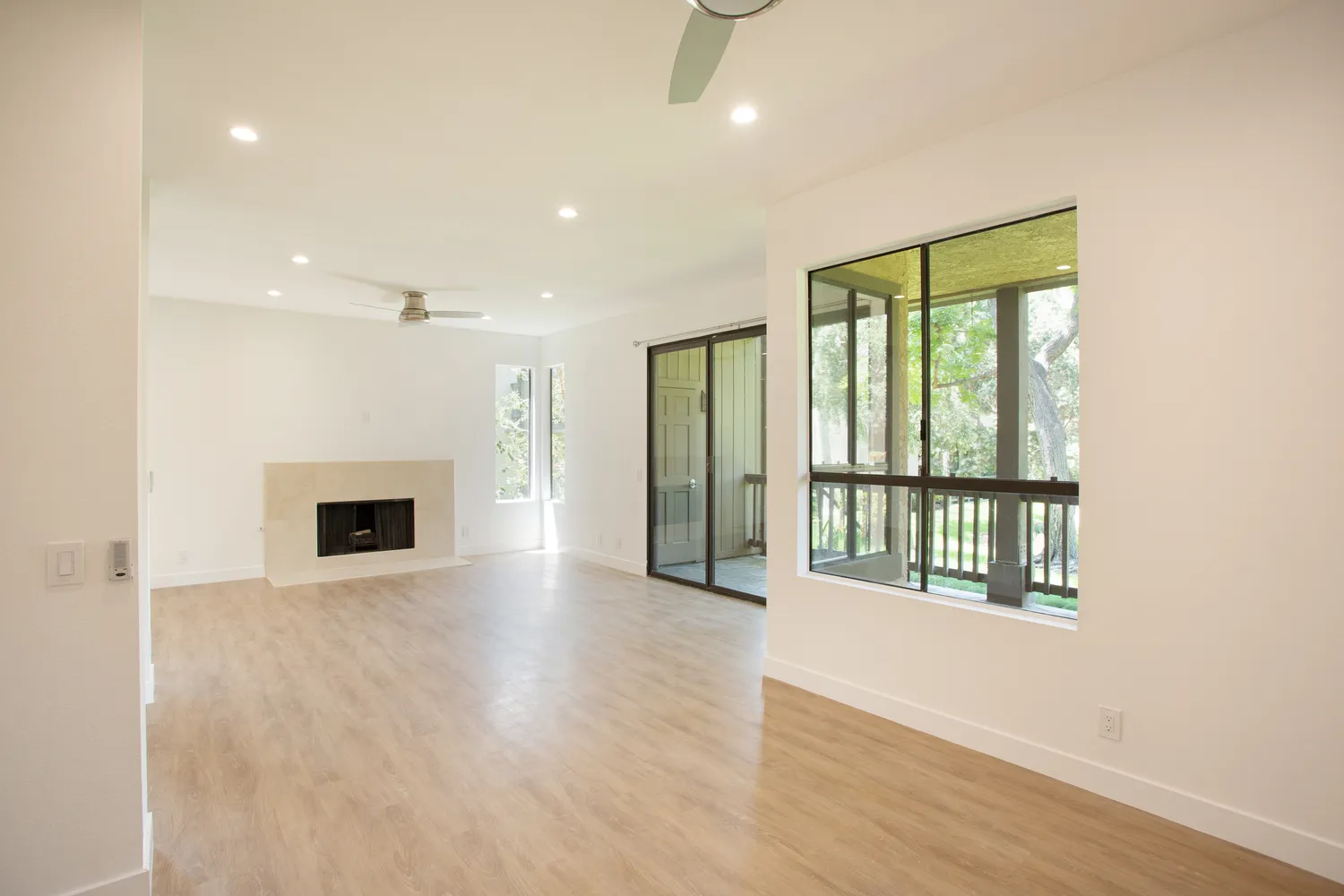 an empty room with wooden floor and a fireplace
