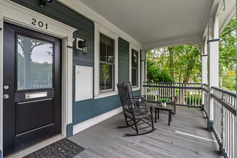 a view of a balcony with chairs and wooden floor