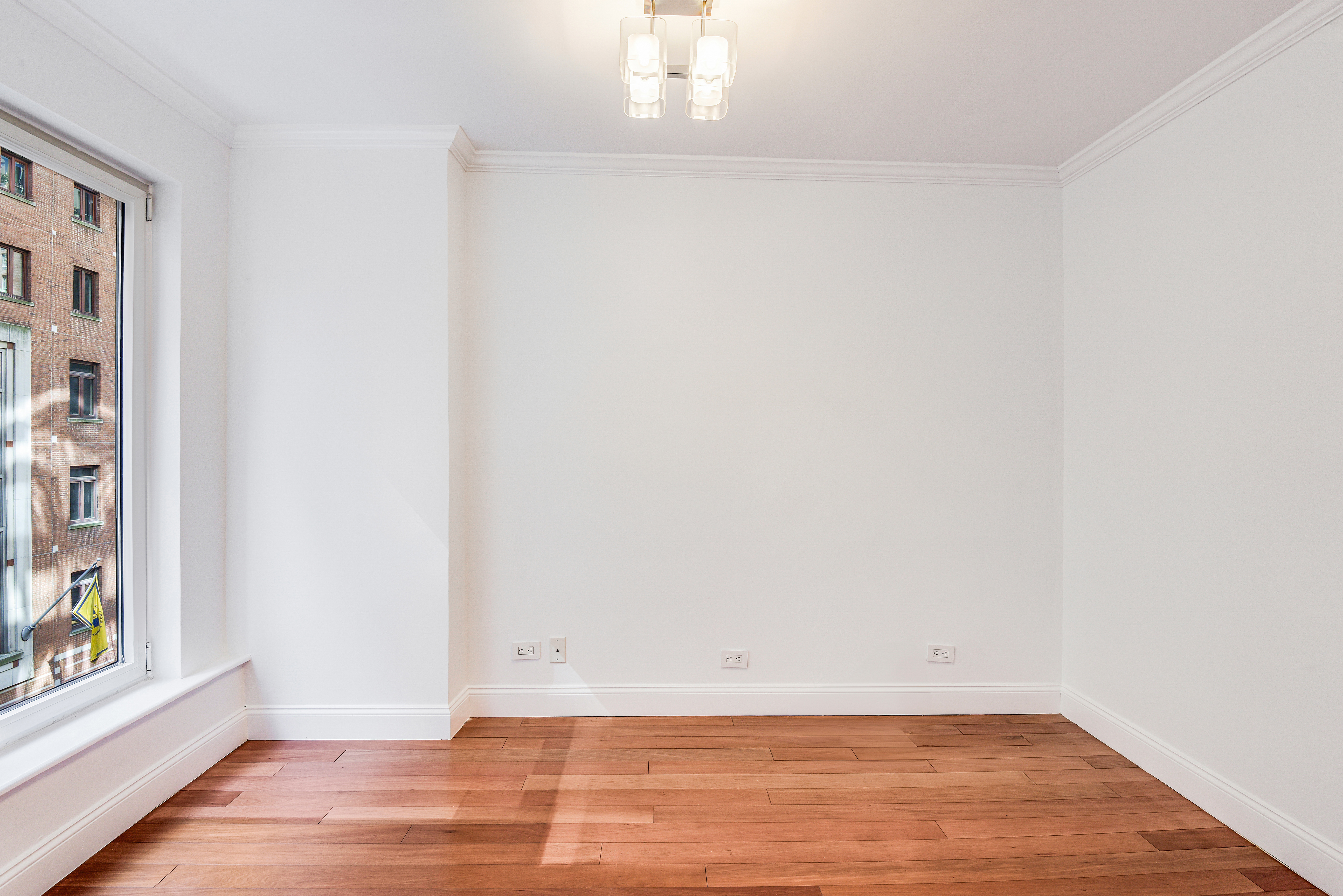 200 Central Park South, Unit 5M Manhattan, NY 10019 - Photo 12 of 15 a view of an empty room with wooden floor and a window