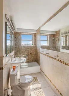 a bathroom with a granite countertop toilet sink and mirror