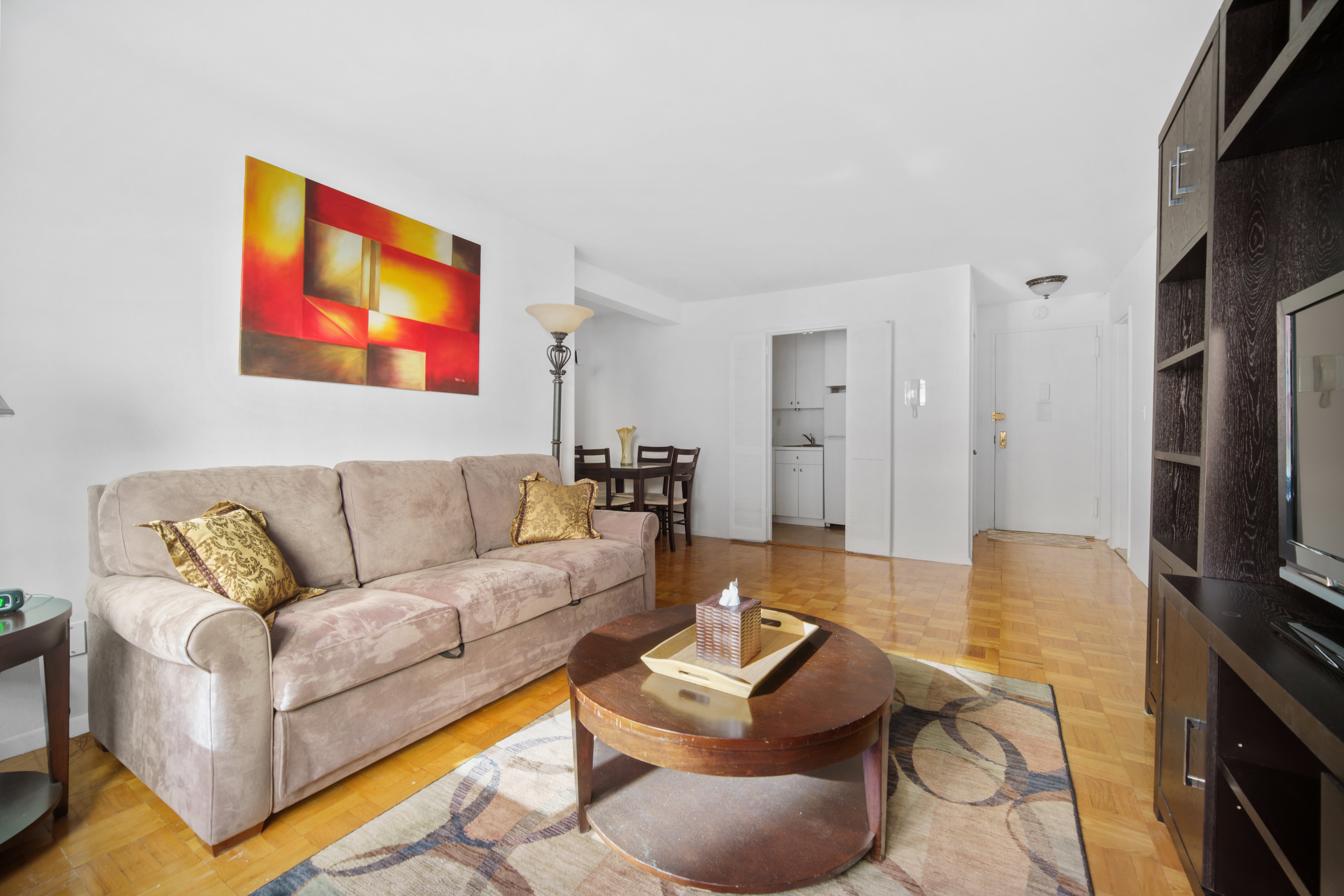 210 East 63rd Street, Unit 5B Manhattan, NY 10065 - Photo 3 of 6 a living room with furniture and a flat screen tv