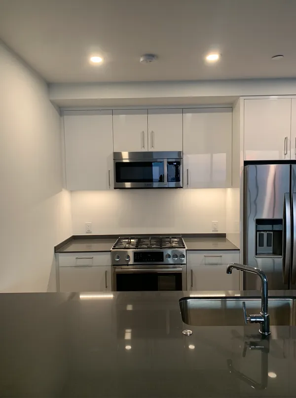 a kitchen with granite countertop a stove and a refrigerator