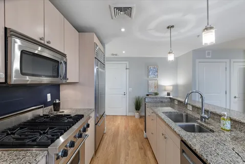 a kitchen with stainless steel appliances granite countertop a sink stove and refrigerator