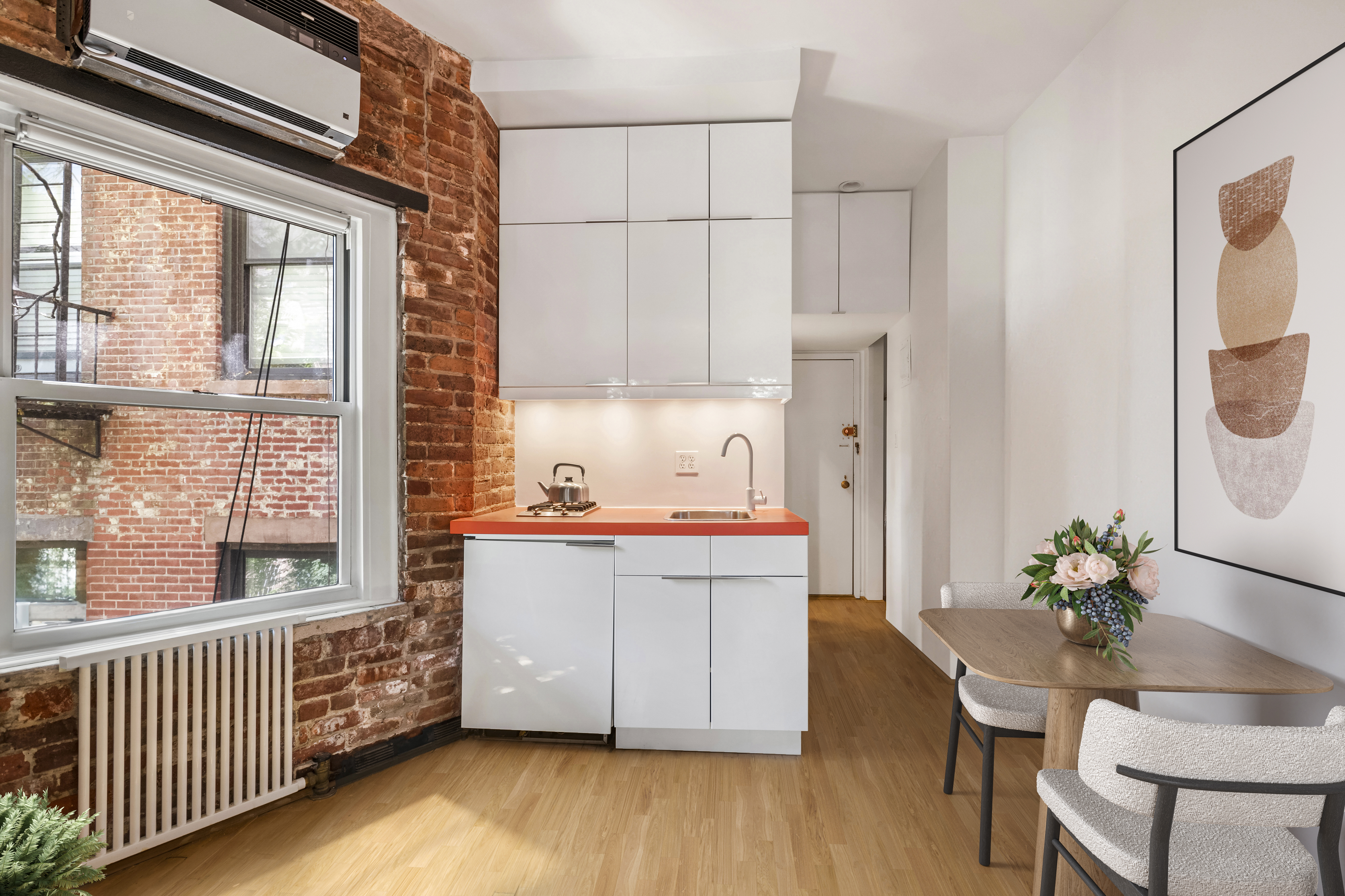 77 Perry Street, Unit 3D Manhattan, NY 10014 - Photo 3 of 11 a kitchen with stainless steel appliances a stove a sink a refrigerator and wooden floor
