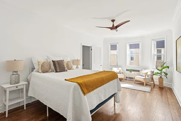 a spacious bedroom with a bed and wooden floor