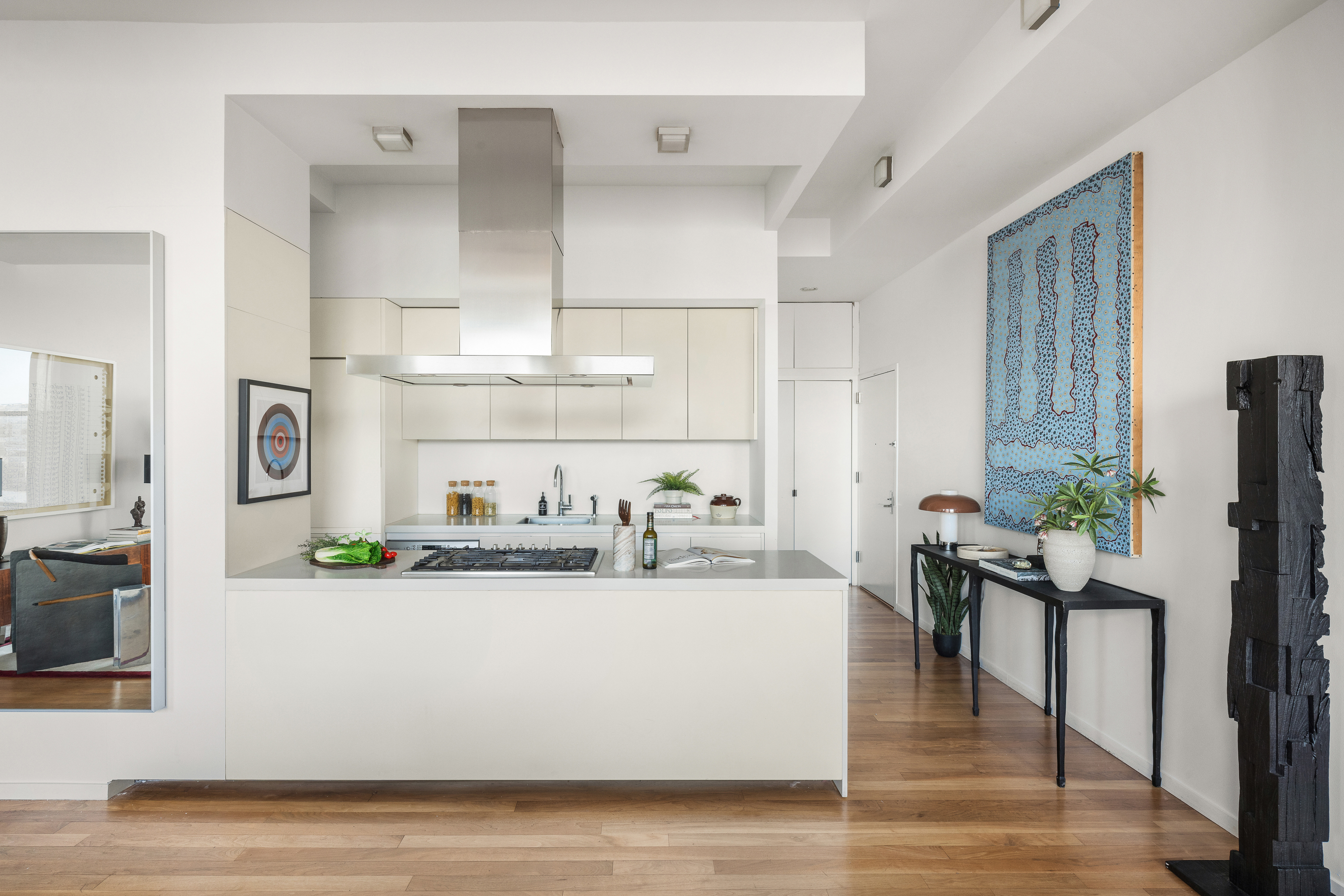 175 East Broadway, Unit 7A Manhattan, NY 10002 - Photo 11 of 24 a living room with stainless steel appliances kitchen island granite countertop a table chairs in it and a flat screen tv