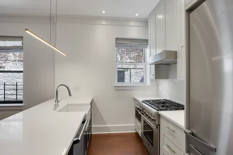 a kitchen with granite countertop a sink and a stove top oven