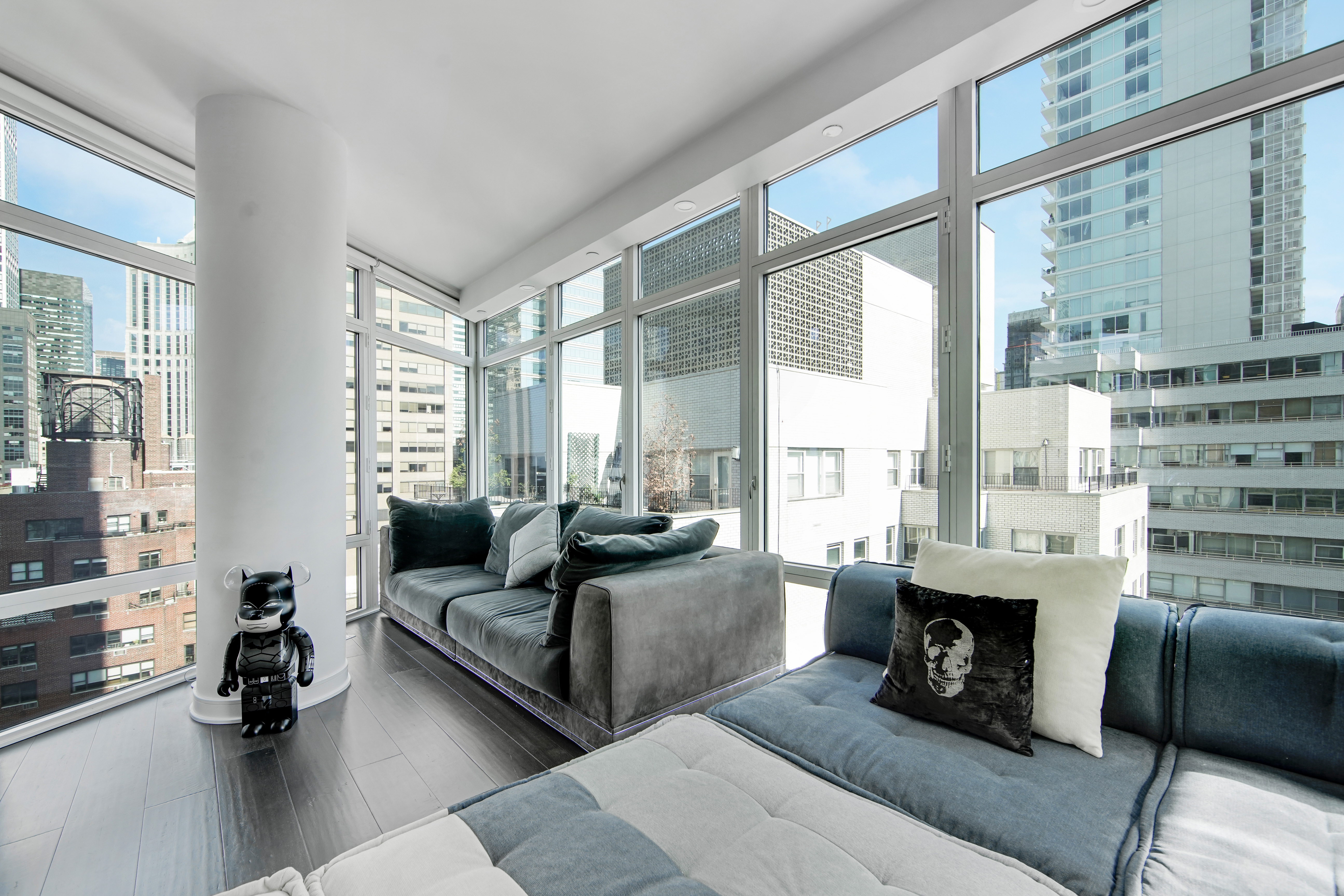 207 East 57th Street, Unit 20A Manhattan, NY 10022 - Photo 2 of 18 a living room with furniture large windows and a fireplace