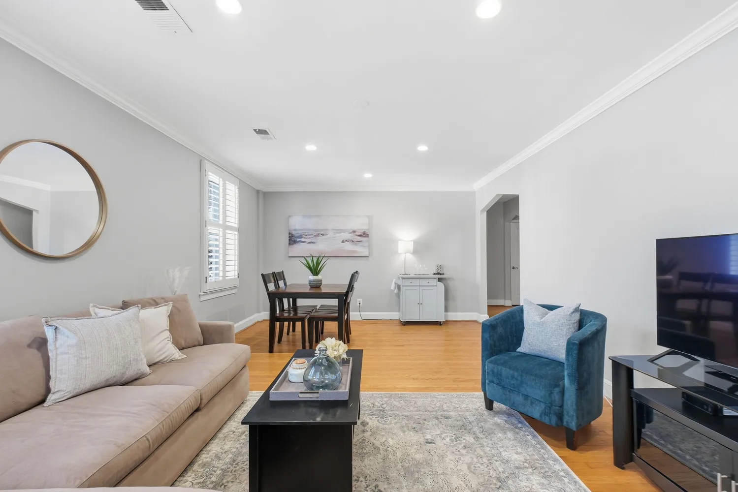 a living room with furniture and a wooden floor