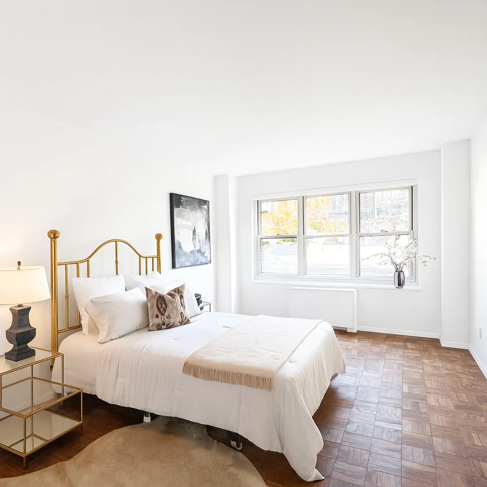 a bedroom with a bed and a large window