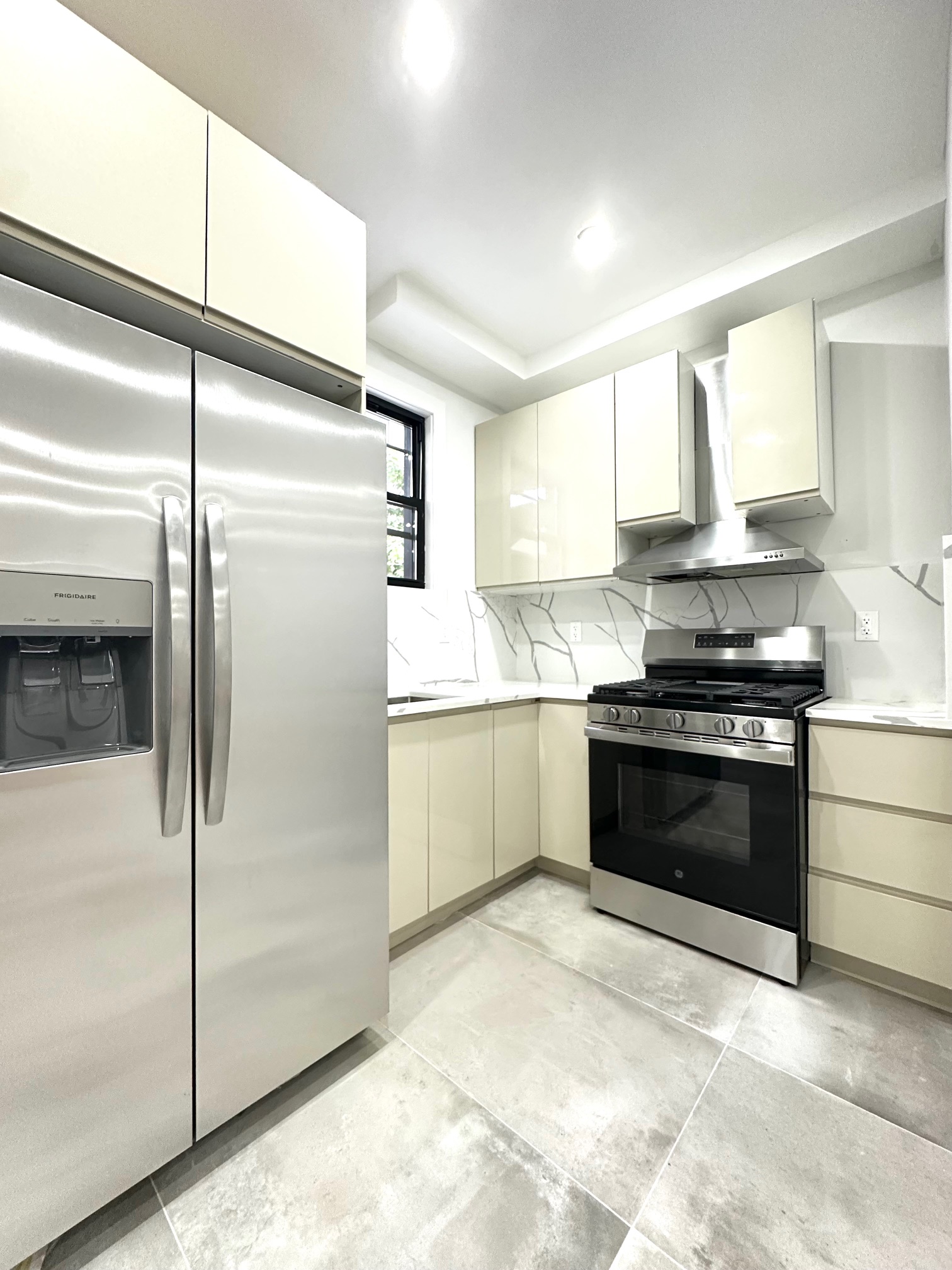 38-18 32nd Street, Unit 1 Queens, NY 11101 - Photo 4 of 6 a kitchen with stainless steel appliances a refrigerator sink and cabinets