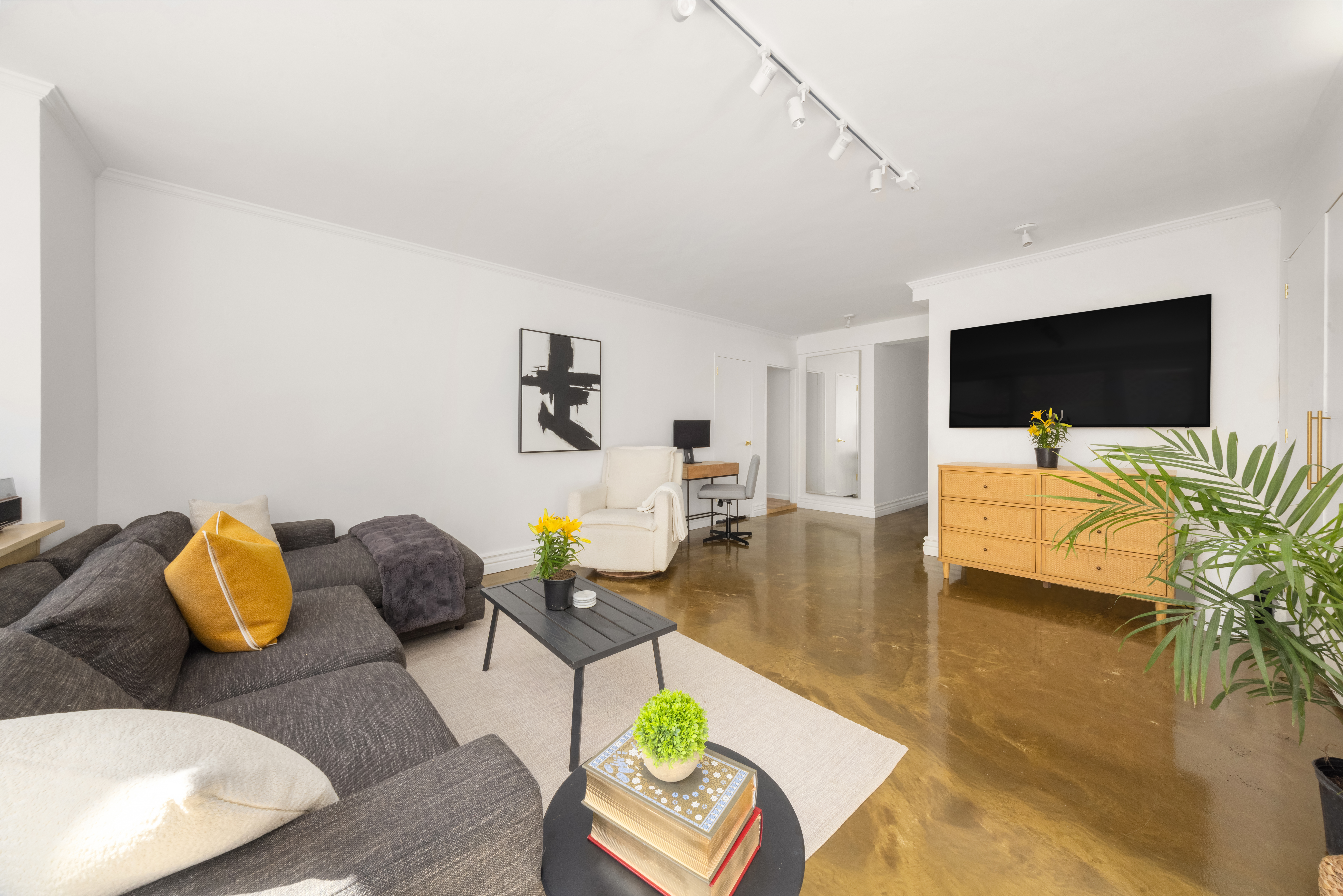 150 East 61st Street, Unit 2A Manhattan, NY 10065 - Photo 3 of 9 a living room with furniture and a flat screen tv